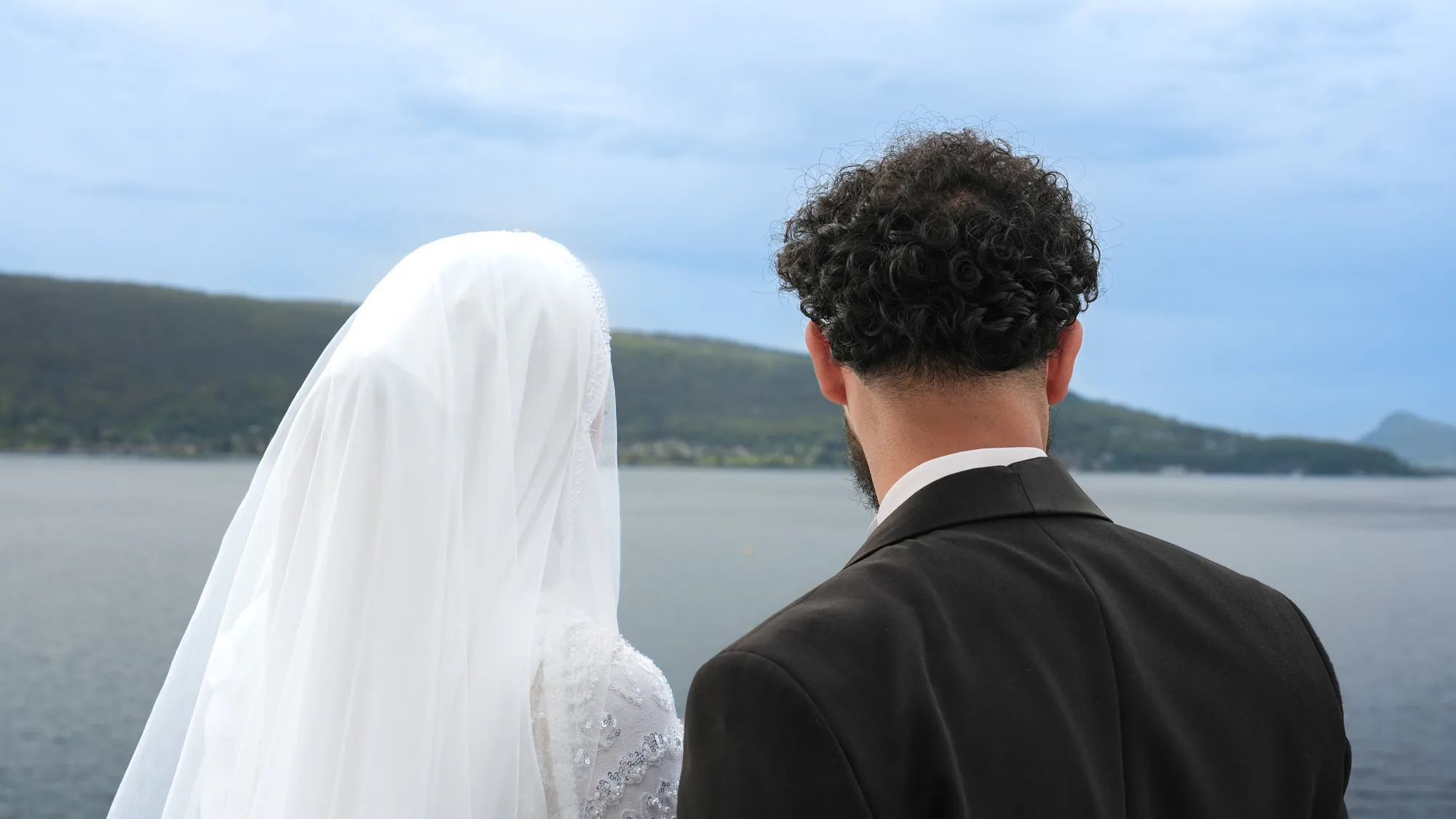 Les mariés de dos face au lac d'Annecy, au Palace de Menthon
