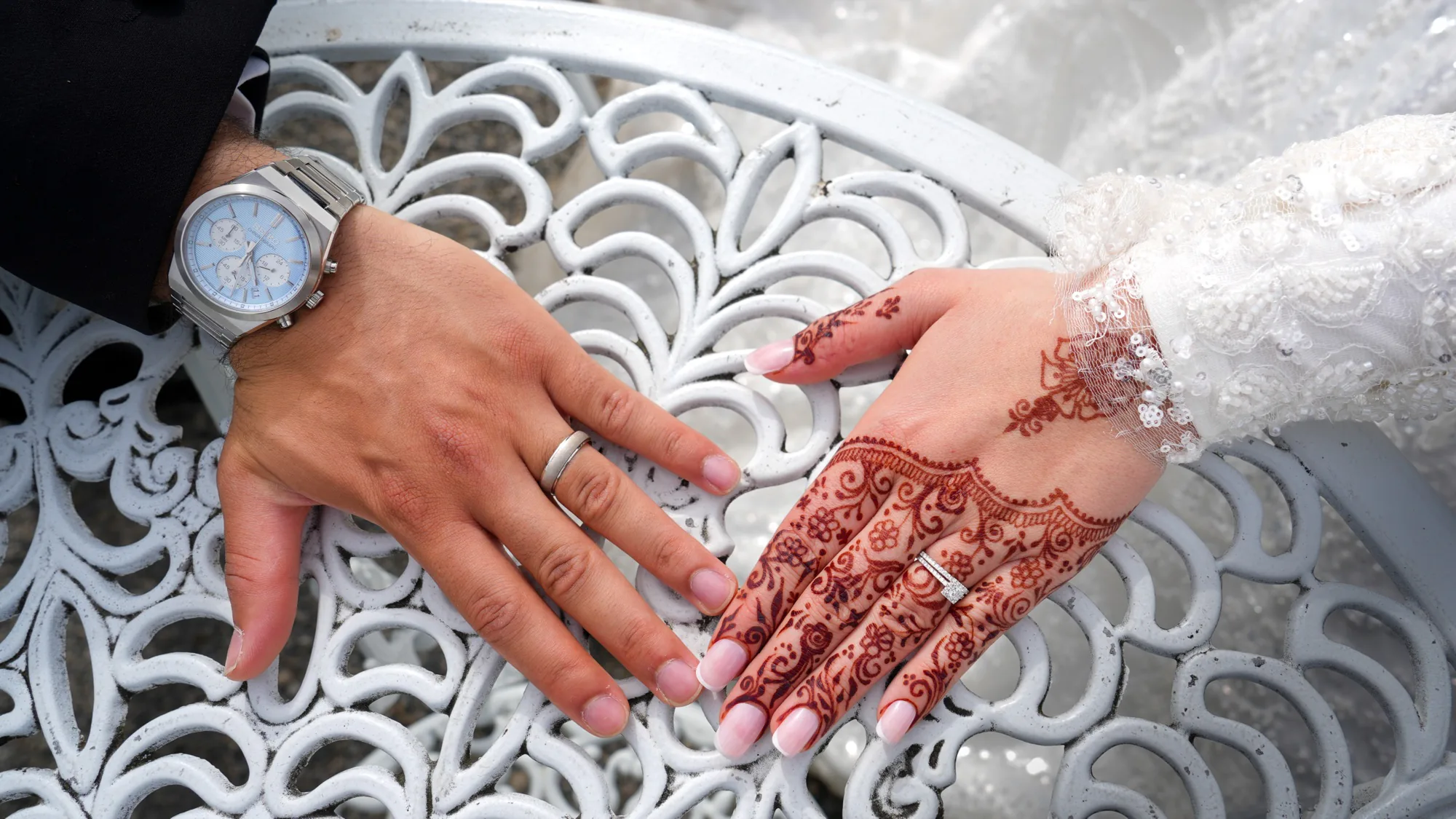 Les mains au henné de la mariée sur celles du marié