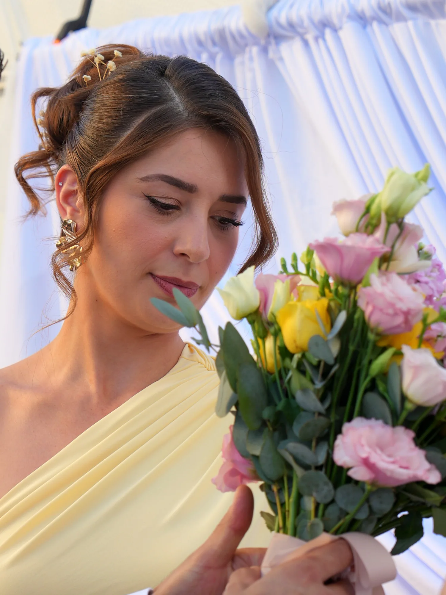 Fatma Nur, bouquet de roses à la main, sous les voilages