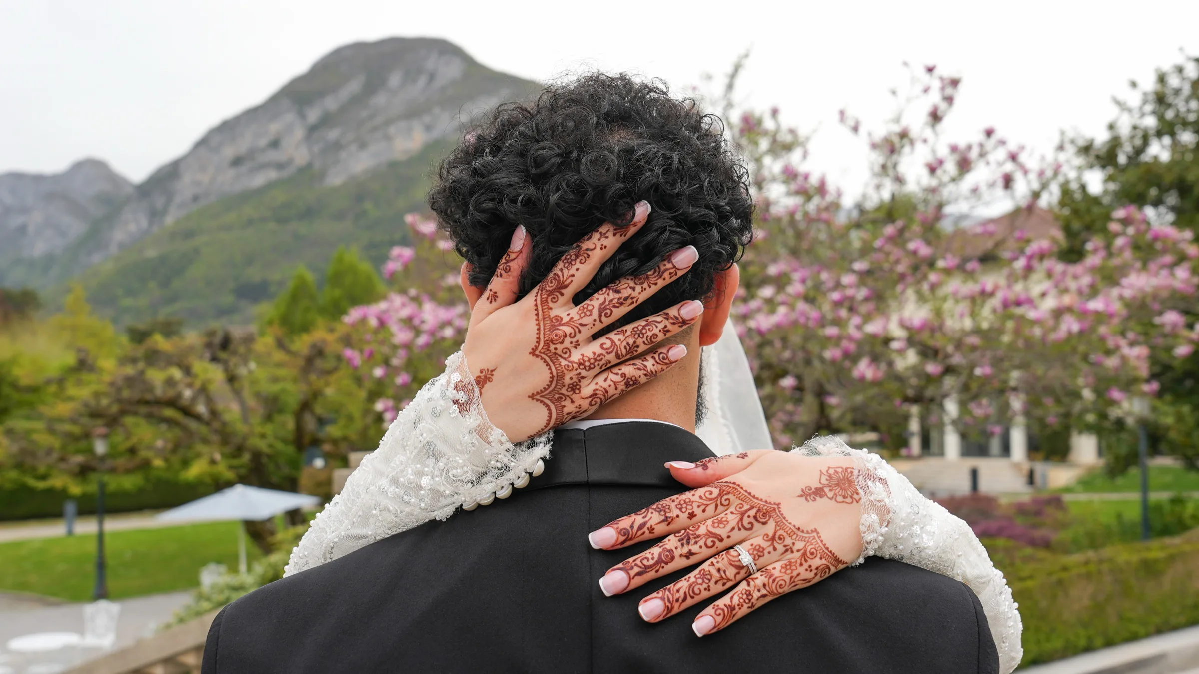 Les mains de la mariée, ornées de henné, posées sur la nuque du marié